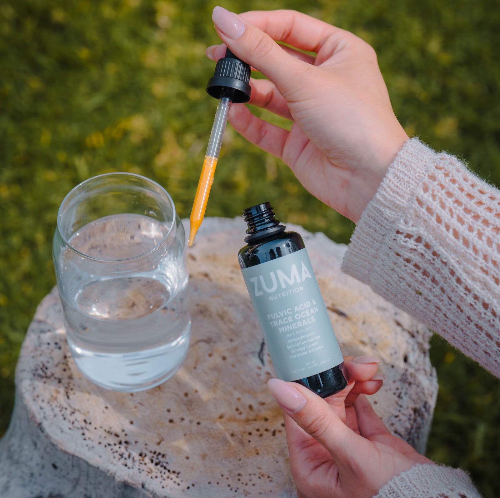 A dropper of Zuma Nutrition Fulvic Acid & Trace Ocean Minerals over a glass of water