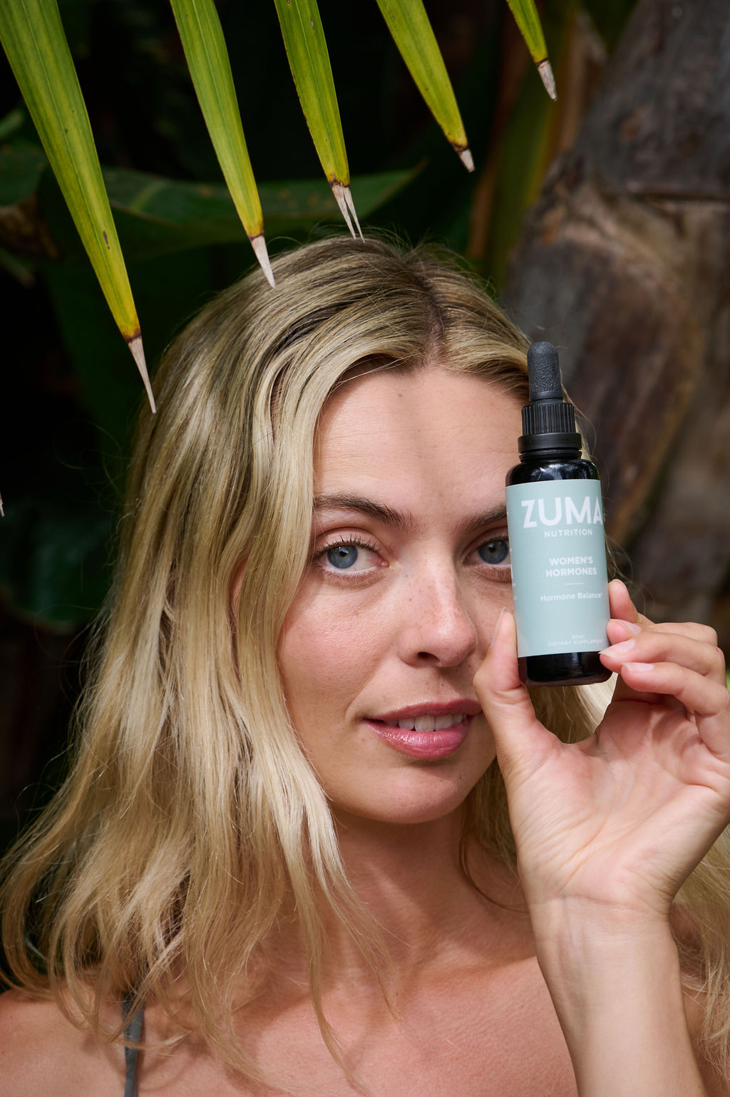 Beautiful blonde woman holding an herbal tincture