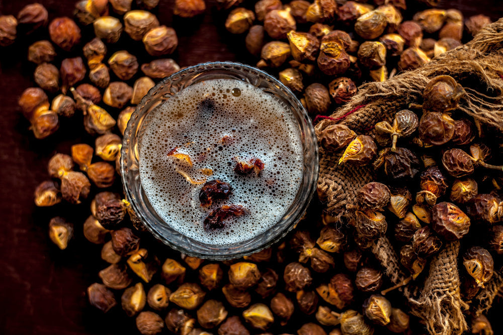 Shot of soapnut or reetha or areetha in a gunny bag along with some of its natural shampoo in a glass bowl.