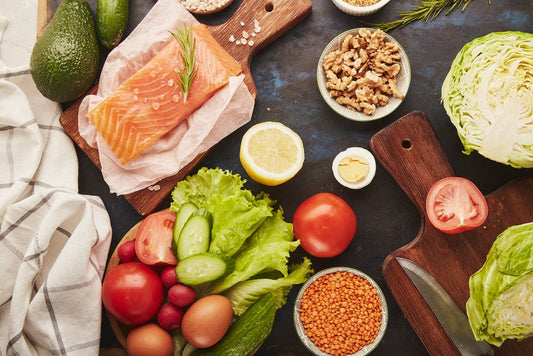 Low-FODMAP SIBO diet foods including vegetables, fruit, walnuts, smoked salmon, greens, and avocado