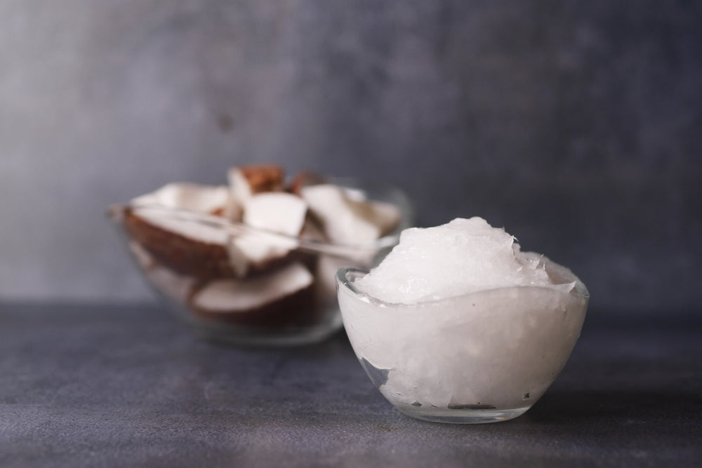 cold coconut oil in a container on black background