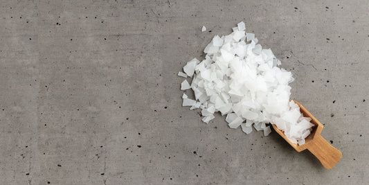 Close-Up of Magnesium Salt Flakes scattered from scoop on grey concrete