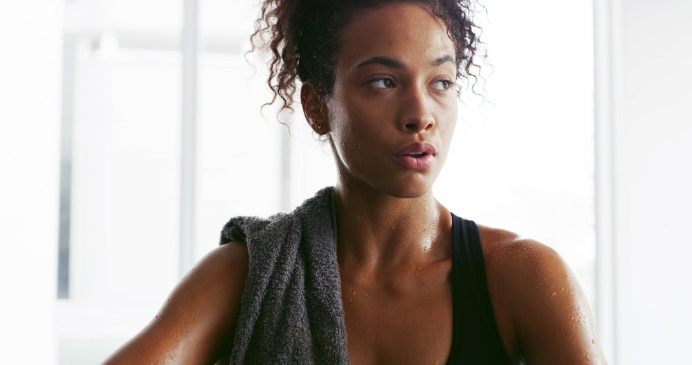 Sweat, towel and woman tired for fitness, intense training and workout at gym in morning. 