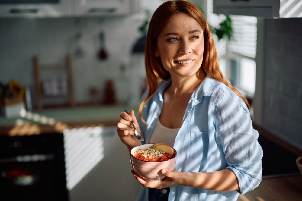 Woman eating a healthy whole-food breakfast bowl