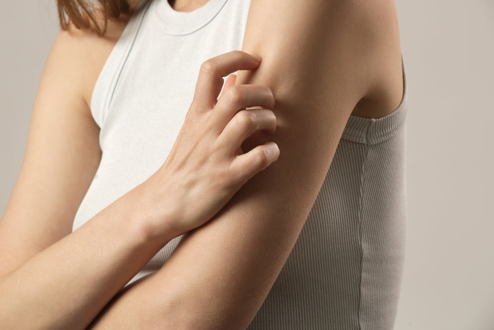 Close up view of woman scratching her arm. Health care and medical concept.