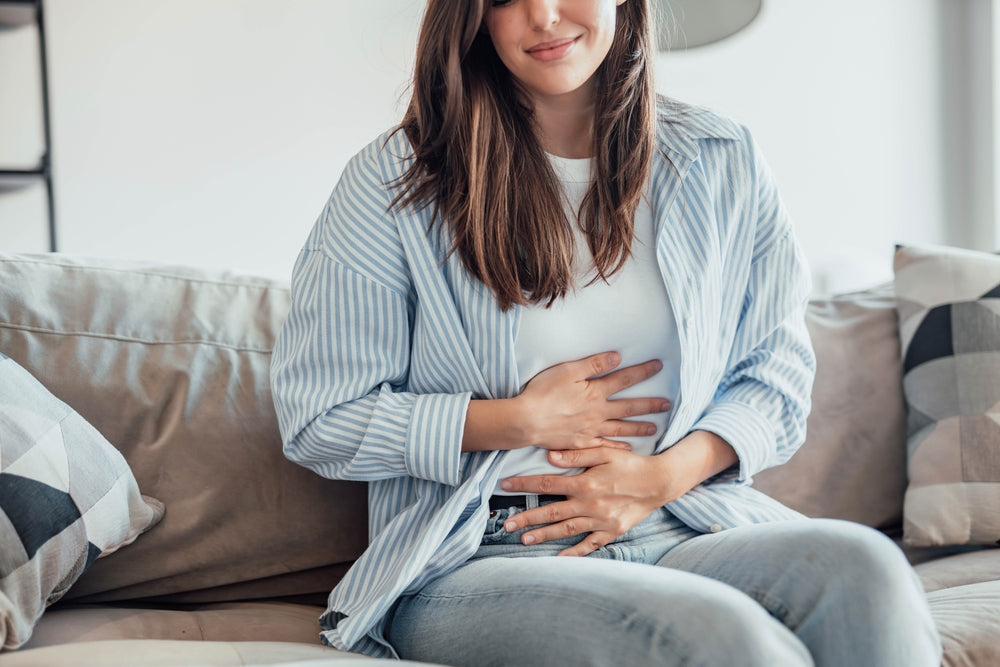Om stomachache alone at home, holding her belly