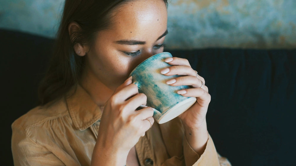 Drinking, sofa and woman with coffee in home for wellness