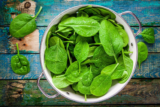 leafy greens in a bowl on a wooden table